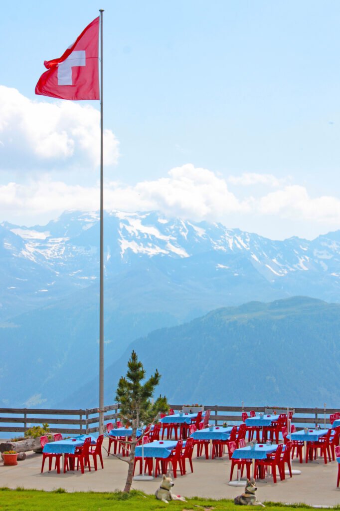 Swiss flag over an alpine landscape, representing the transition from Swiss wealth tax to Cyprus tax residency.